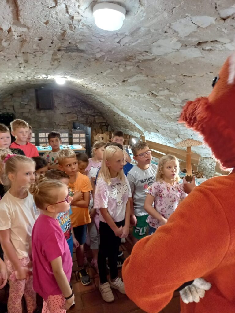 Děti naslouchají animátorovi během exkurze